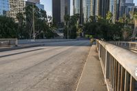 a car is parked underneath the bridge on a city street with tall buildings behind it