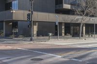 a man on a bike crosses the street to the corner of the street next to an empty building