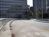 a city street is deserted with an empty walkway next to it and skyscrapers in the background