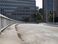 a city street is deserted with an empty walkway next to it and skyscrapers in the background