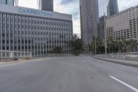 an empty city street with a few buildings and palm trees along it's side