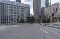 an empty city street with a few buildings and palm trees along it's side