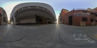 the distorted fish - eye shot shows the cars on the street and in the car parking lot