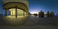 fish eye image at the base of a building with light reflecting off of it's glass windows