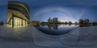 a fish eye view of a reflection of an urban landscape at dusk, taken from the river