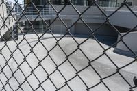 a fenced in area with stairs and stairs leading to a high rise building in the background