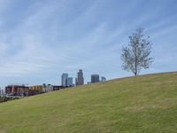 a view of the downtown area of an industrial area with grass and a bridge that has been closed down