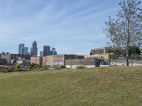 a view of the downtown area of an industrial area with grass and a bridge that has been closed down