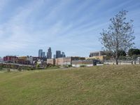 a view of the downtown area of an industrial area with grass and a bridge that has been closed down