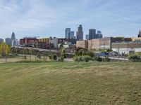 a view of the downtown area of an industrial area with grass and a bridge that has been closed down