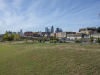 a view of the downtown area of an industrial area with grass and a bridge that has been closed down