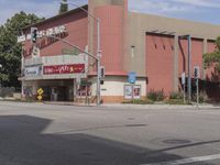 a photo of an old movie theater and a stoplight by the intersection of street