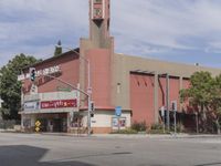 a photo of an old movie theater and a stoplight by the intersection of street