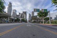 an empty street with multiple signs that say go ahead and bicycle path with buildings in the background