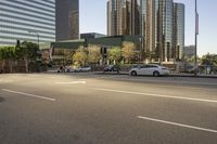 a white car parked next to an intersection with skyscrapers in the background and traffic