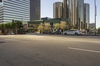 a white car parked next to an intersection with skyscrapers in the background and traffic