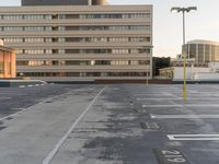 an empty parking lot with a traffic light and buildings in the background for example, there is only one lane to take up the space