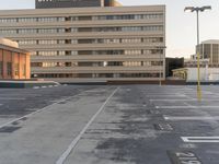 an empty parking lot with a traffic light and buildings in the background for example, there is only one lane to take up the space