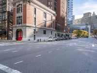 a car drives down the street next to many tall buildings on both sides of the road