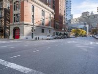a car drives down the street next to many tall buildings on both sides of the road