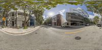 a wide angle view of a downtown street taken with a fisheye lens of buildings and trees