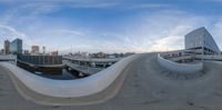 a fisheye view of an outdoor area with many buildings in the distance and an open rooftop