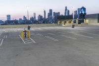 an empty parking lot with a clock tower in the background in the foreground with a view of city and skyscrapers