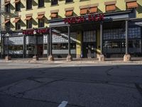 a red stop sign stands outside a yellow and brown building with a brown sign on it that says the fire house