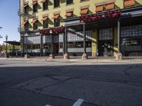 a red stop sign stands outside a yellow and brown building with a brown sign on it that says the fire house