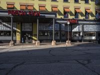 a red stop sign stands outside a yellow and brown building with a brown sign on it that says the fire house