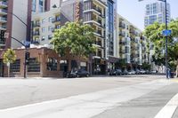an intersection that has cars, motorcycles and buildings in it on the side of the road