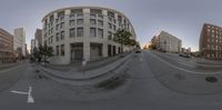 a 360 - vr spherical view looking down the street at traffic signals and buildings on one side of it