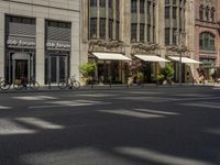 a picture of a street with several people walking and bicycles parked and two people walking with their hands in the ground