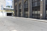 a building with tall windows and a brick sidewalk with no cars on it in front