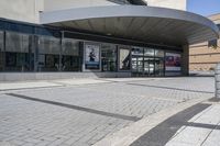 a person sitting at the bench in front of a mall that is empty of people