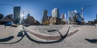 a round photo taken in a 360 - lens at a city intersection with tall buildings and traffic