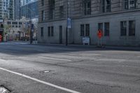 a street corner that is empty with an orange arrow on the curb and cars driving on it