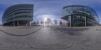 a panorama lens of a modern building on a city street that is empty and with pedestrians crossing the sidewalk