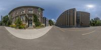 a view through the fish eye lens of a big building on the corner with a parking lot near it