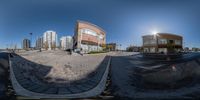 a view from a fish eye lens of the street with some cars and buildings in the background