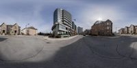 two large buildings are seen through the circular mirror lens with buildings behind them in an urban setting