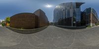 the 360 - view lens is on the street near the building and sign post in the foreground