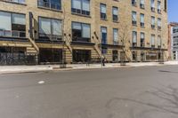 there are many windows on this building and people walking the sidewalk outside there is a red bicycle in front of the building