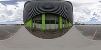 a mirror image of a building with an outside space in the front ground and one side of a road in front of it