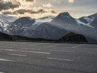 a picture of the mountains are behind the road as the man walks on the road