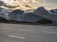 a picture of the mountains are behind the road as the man walks on the road