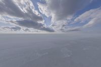 the sky with white clouds and a cloud is visible in the snow with snow patches