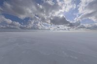 the sky with white clouds and a cloud is visible in the snow with snow patches