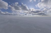 the sky with white clouds and a cloud is visible in the snow with snow patches