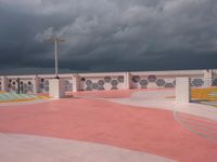 the concrete walkway and sky is very dramatic in this photo the street is painted pink